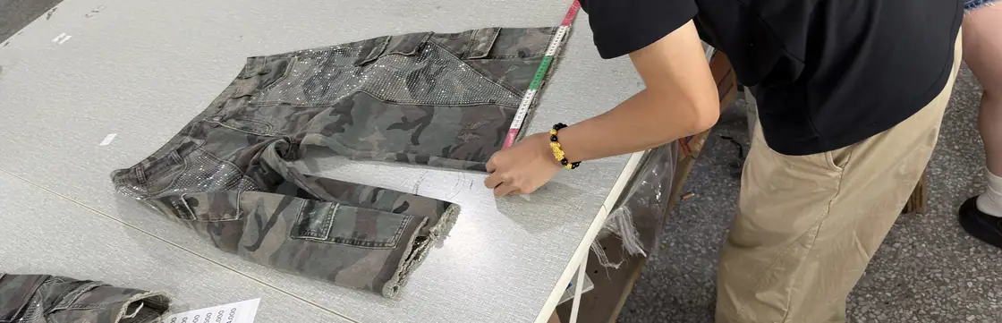 MISEN quality inspector measuring a finished denim garment
